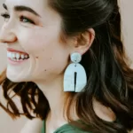 uśmiechająca się kobieta z ceramicznym kolczykiem w uchu